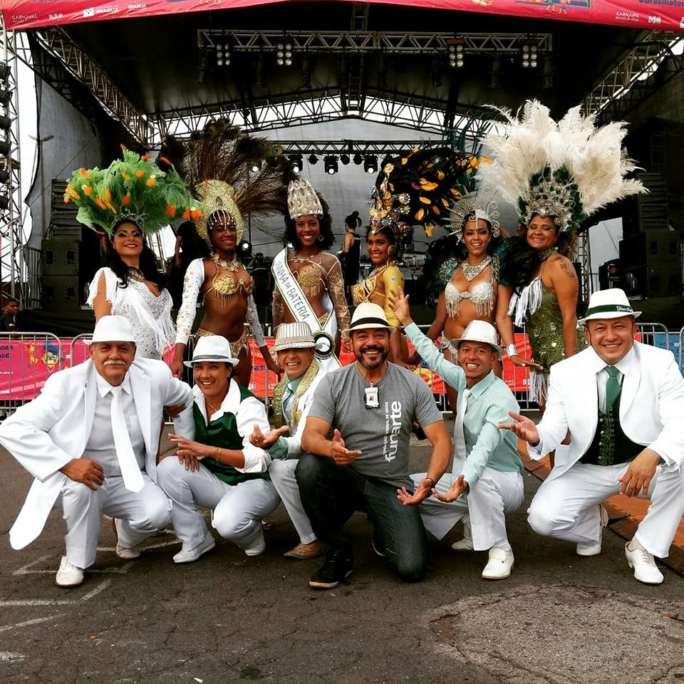 João Carlos Corrêa com artistas em figurinos de carnaval diante de um palco na área externa do Complexo Cultural Funarte de Brasília