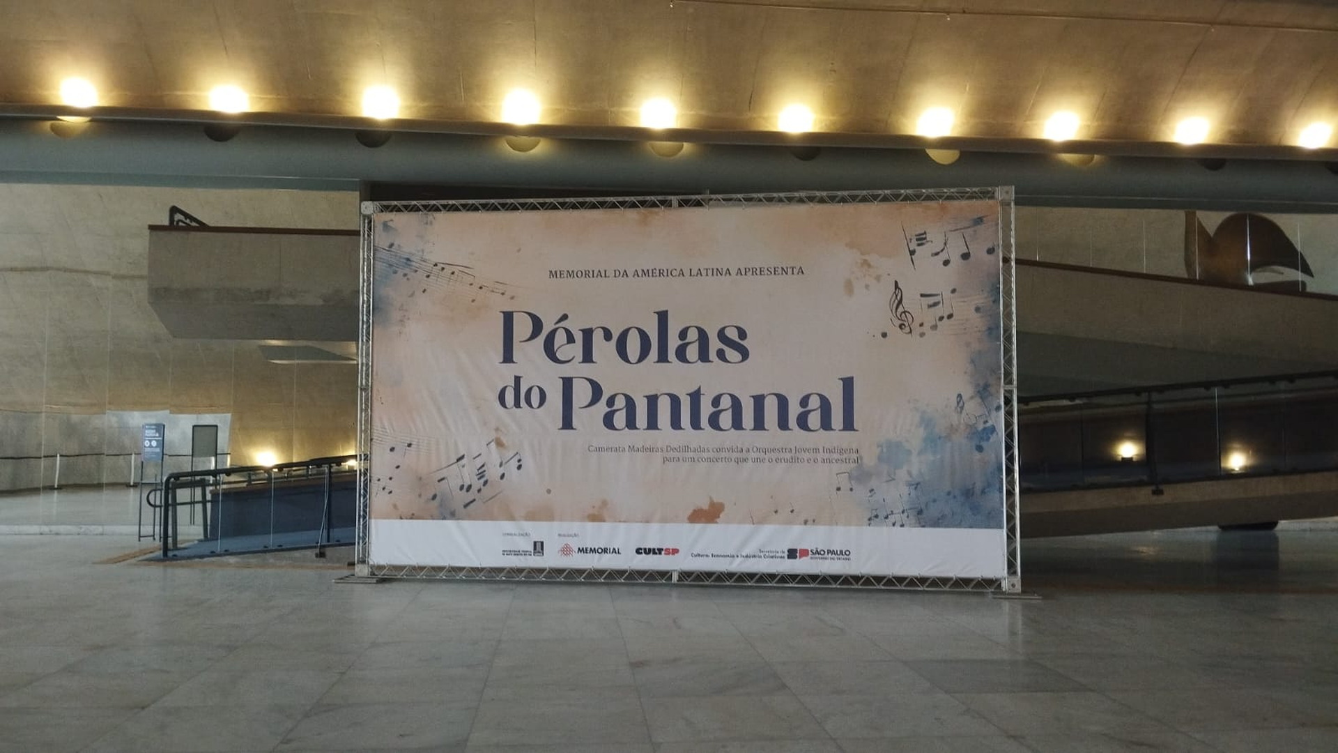 Cartel de la exposición Pérolas do Pantanal instalado en un espacio interior del Memorial da América Latina