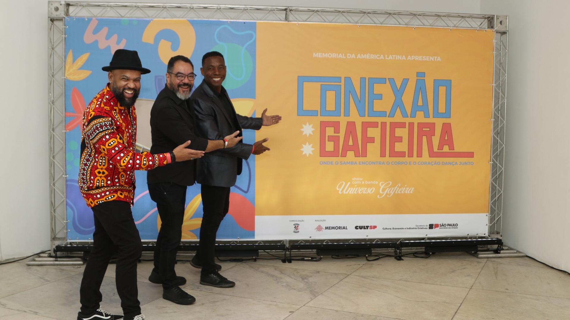 João Carlos Corrêa y un invitado posan ante el panel del proyecto Conexão Gafieira
