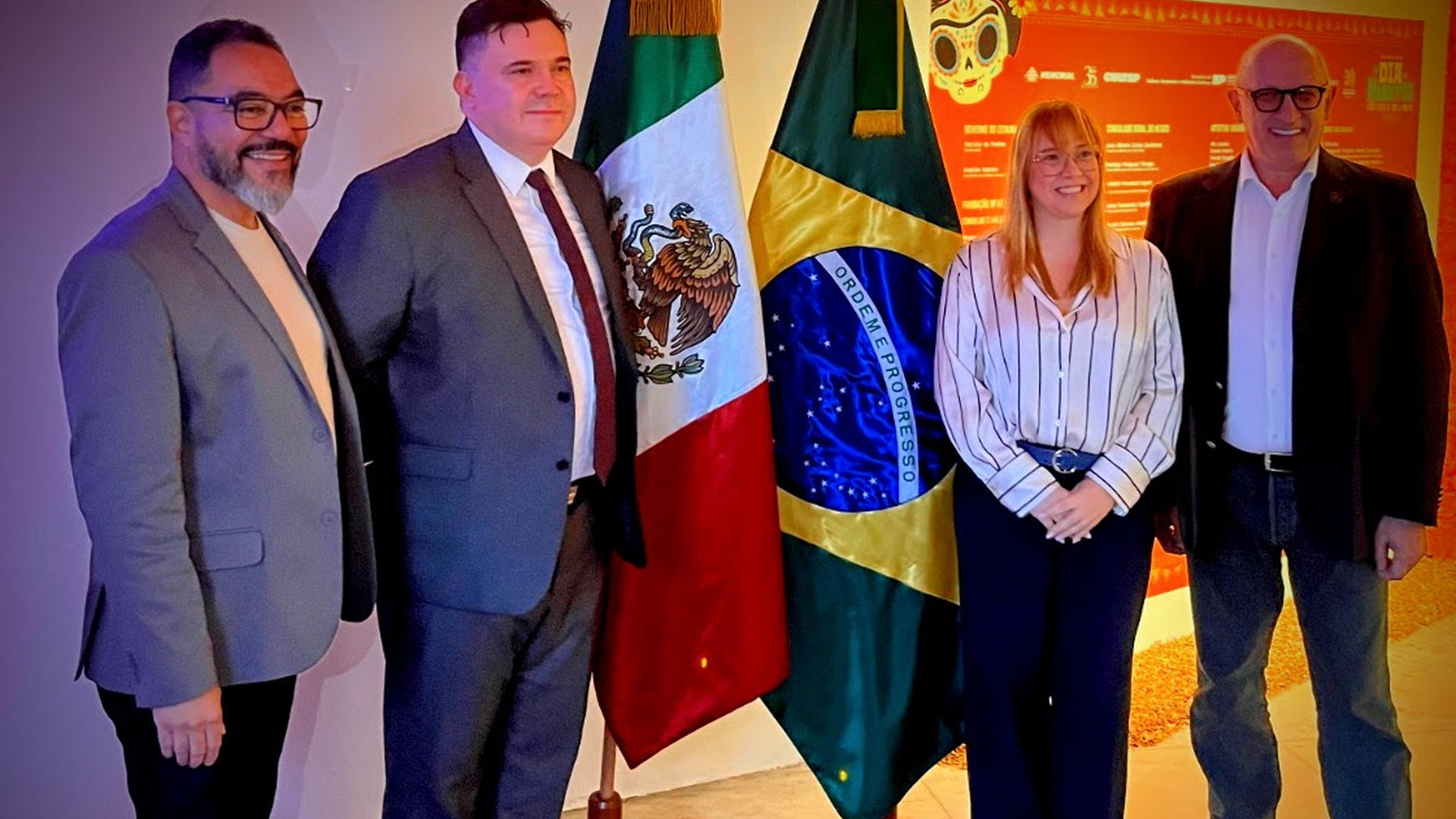Cuatro representantes posan entre las banderas de México y Brasil en un ambiente institucional