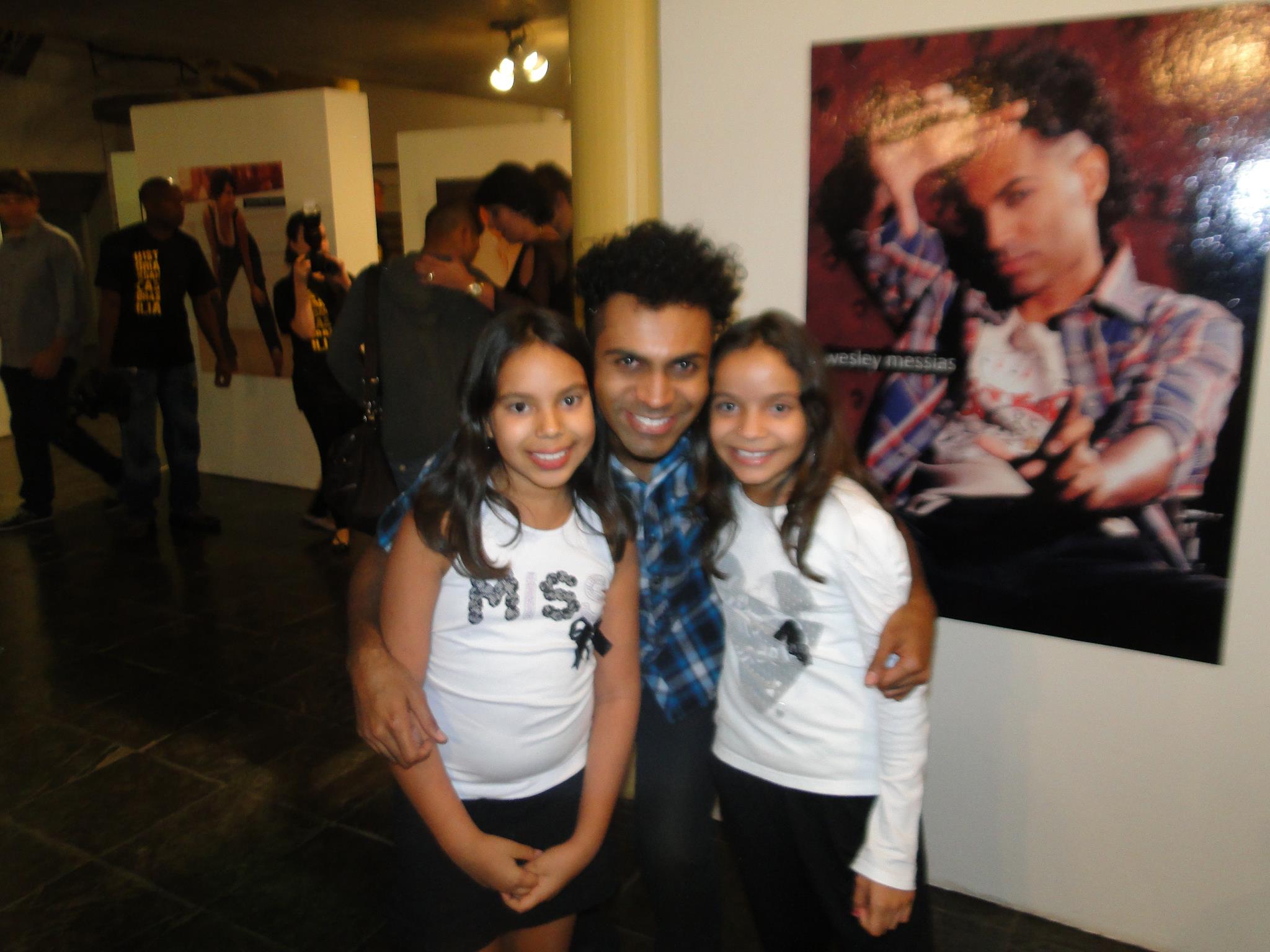 Visitante adulto e duas crianças posam na exposição sobre a história da dança em Brasília