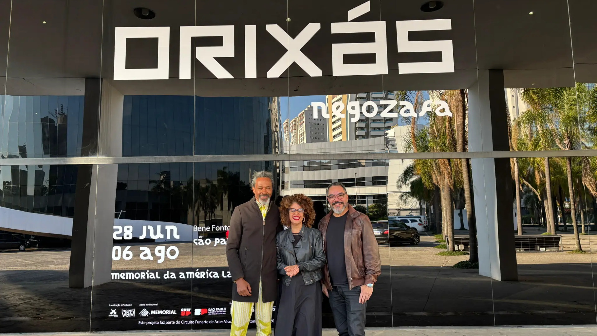 João Carlos Corrêa e invitados posan ante la entrada de la exposición Orixás, de Ifatola Bezerra