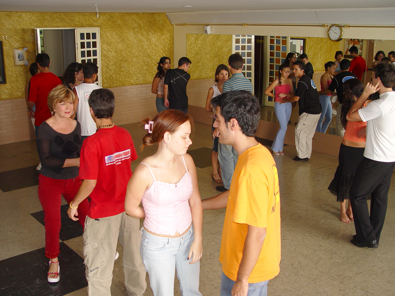 Diversos pares praticam dança de salão durante aula coletiva na Academia Estilo e Dança