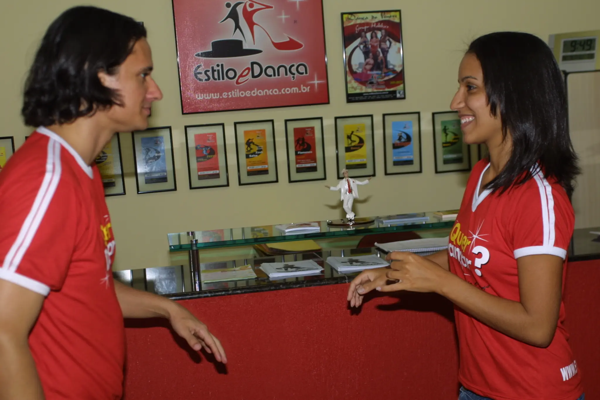 Dois integrantes conversam diante da recepção e da identidade visual da Academia Estilo e Dança