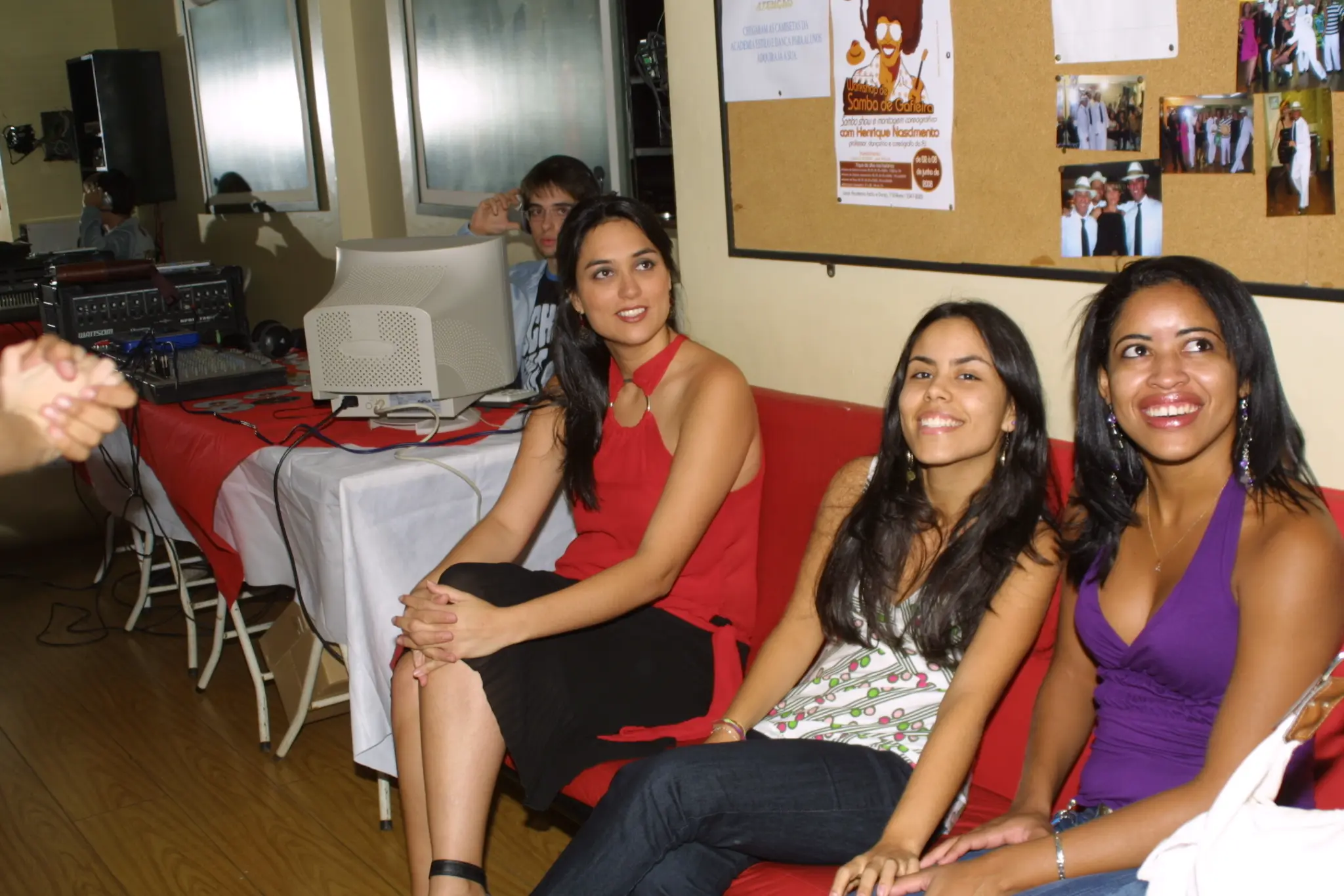 Três participantes sentadas próximas à mesa de som durante evento na Academia Estilo e Dança