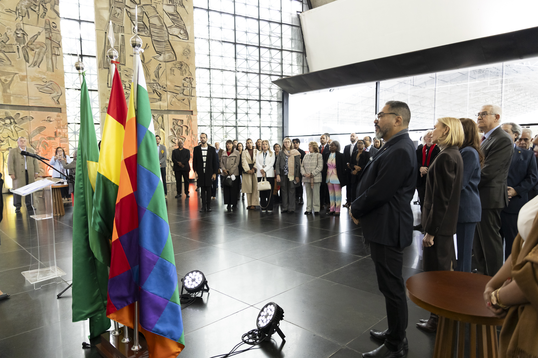 Autoridades e invitados siguen la ceremonia ante cuatro banderas, entre ellas las de Bolivia y Brasil, en el Memorial