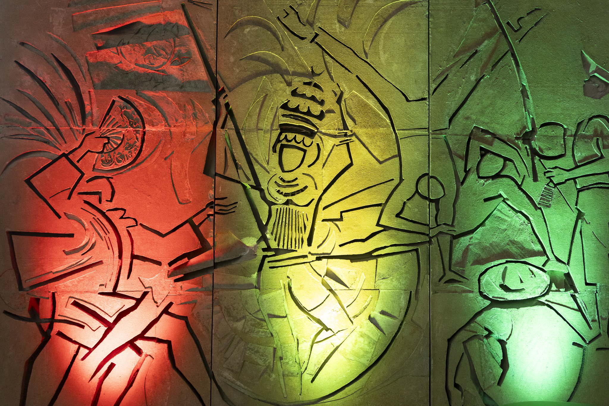 Detalle de un panel artístico en relieve, iluminado en colores rojo, amarillo y verde, durante la celebración del Bicentenario de Bolivia