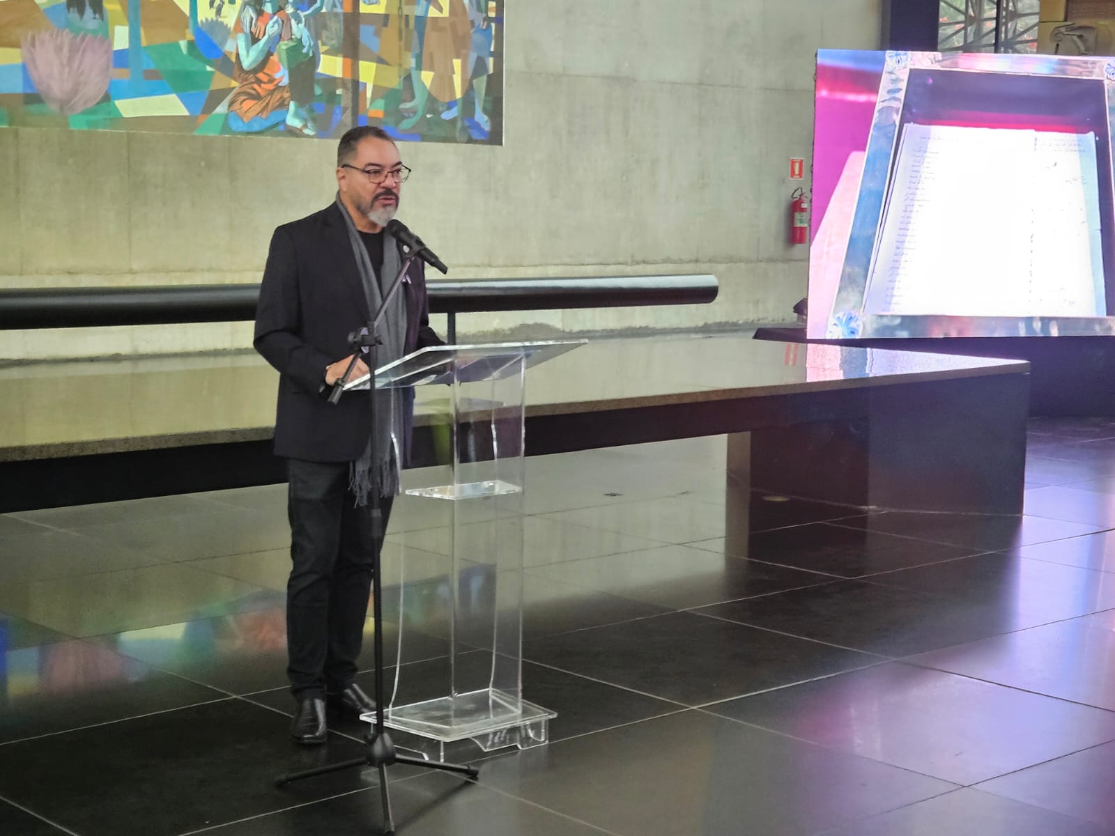 João Carlos Corrêa pronuncia un discurso desde un atril transparente durante la ceremonia del Bicentenario de Bolivia en el Memorial
