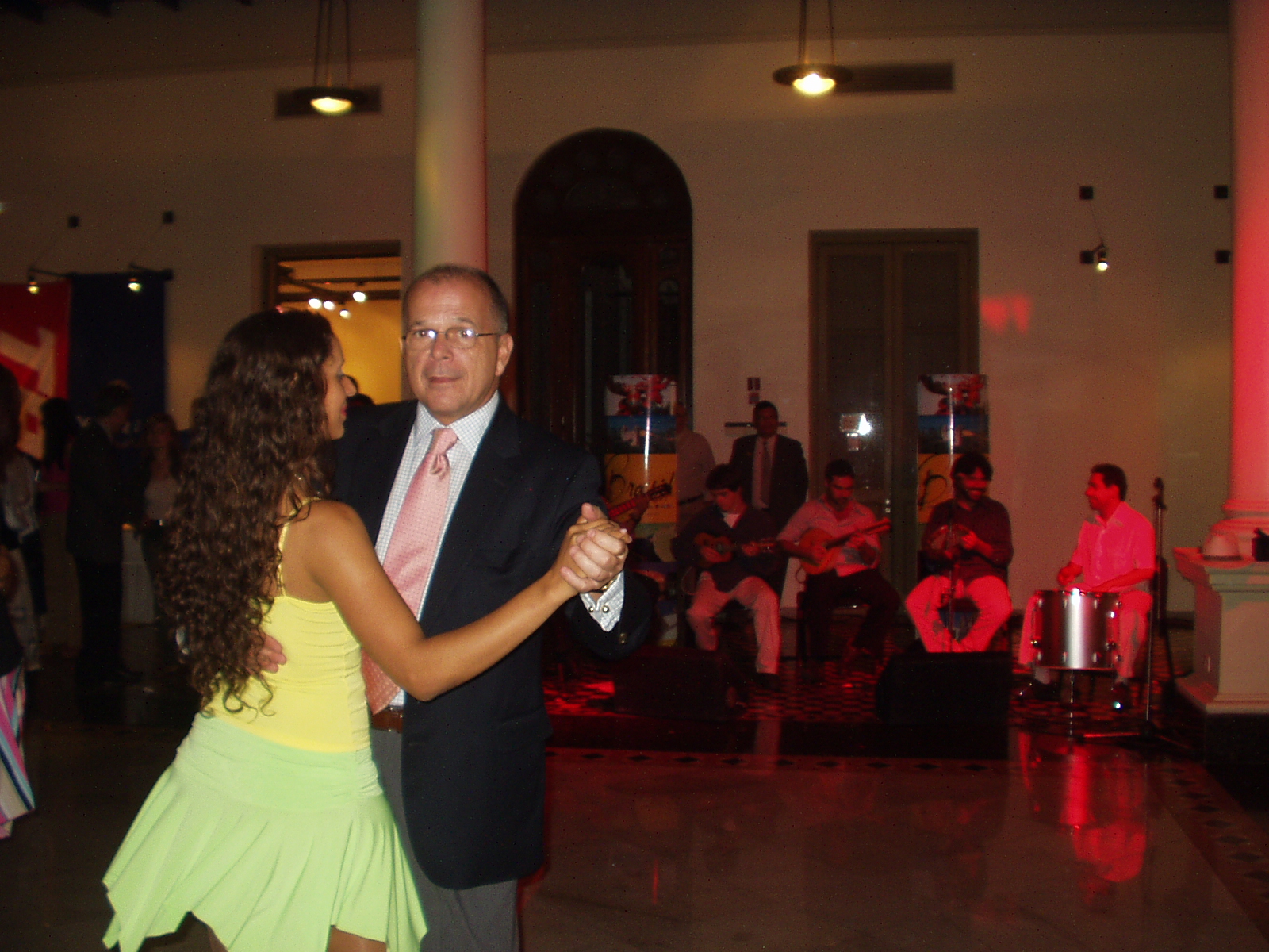 Integrante do Grupo Brasilidade dança com um convidado diante dos músicos na Feira de Turismo Brasil e Paraguai, em Assunção, em 2005