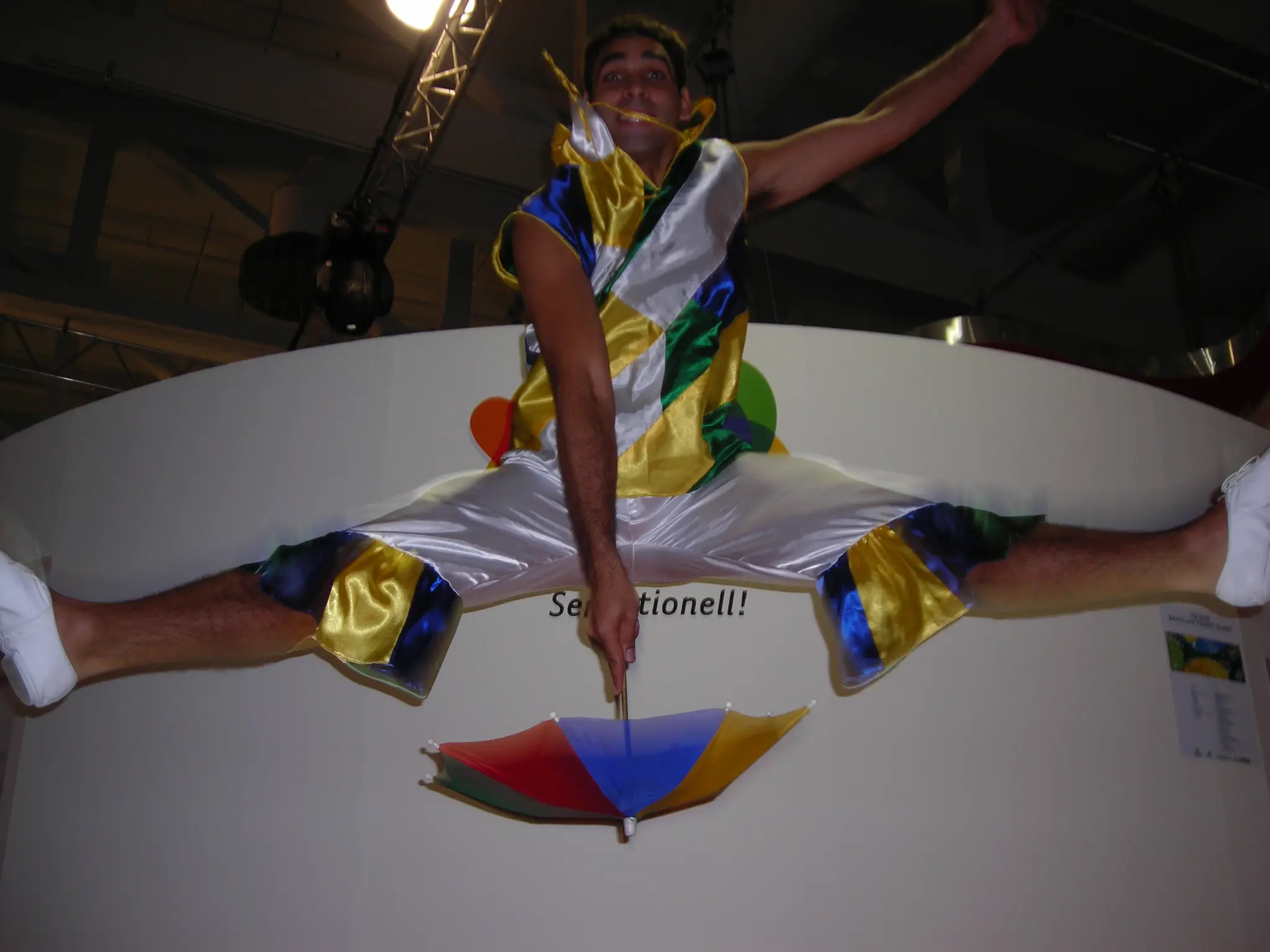 Integrante do Grupo Brasilidade realiza salto coreográfico sobre uma sombrinha colorida durante a missão em Berlim, em 2007