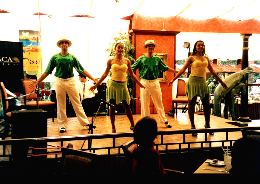 Integrantes e participantes reunidos diante de painel com a marca do Peru durante a Semana Cultural Brasileira em Lima, em 2004