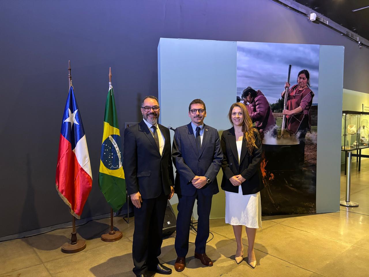 João Carlos Corrêa, Sebastián Depolo y Vanessa Pohl posan junto a las banderas de Chile y Brasil en la apertura de la exposición