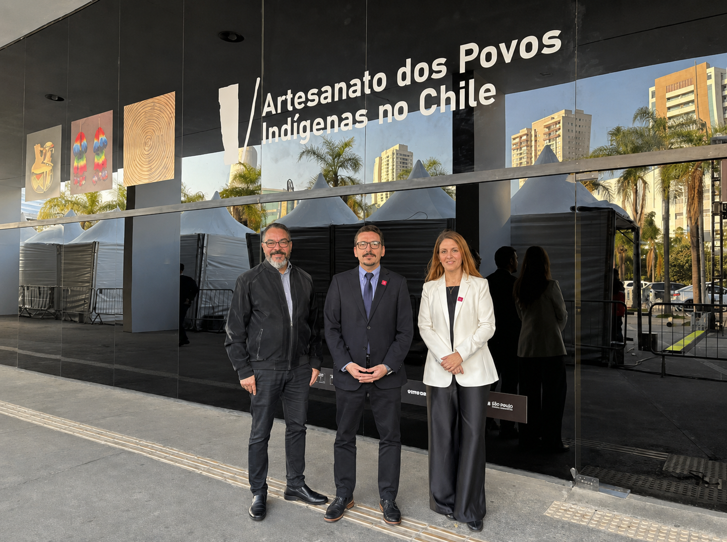 João Carlos Corrêa, Sebastián Depolo y Vanessa Pohl posan frente al Espaço Expositivo Gabo y al título de la muestra sobre artesanía indígena chilena