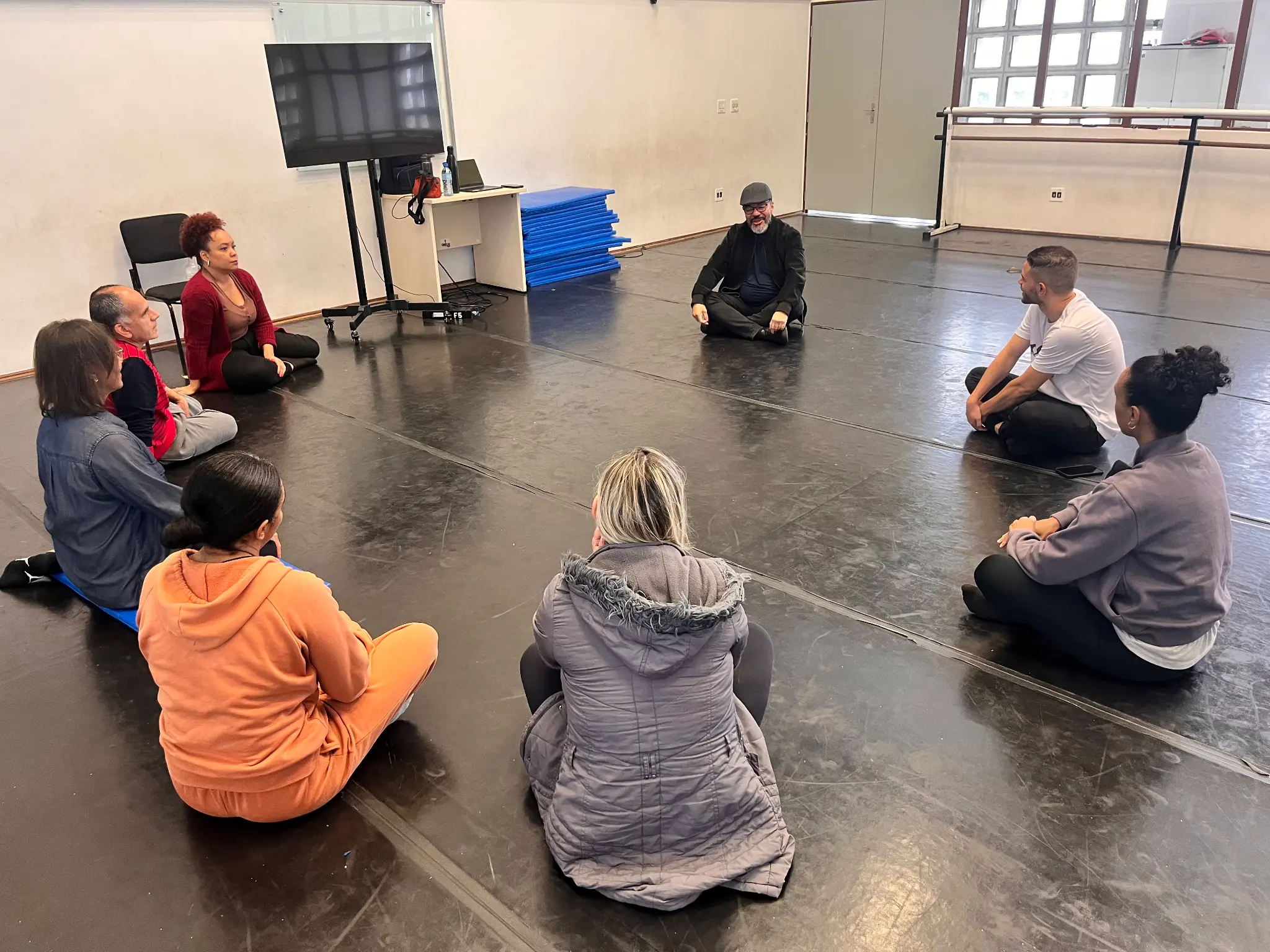 João Carlos Corrêa e participantes sentados em roda durante encontro na Fábrica de Cultura Cidade Tiradentes