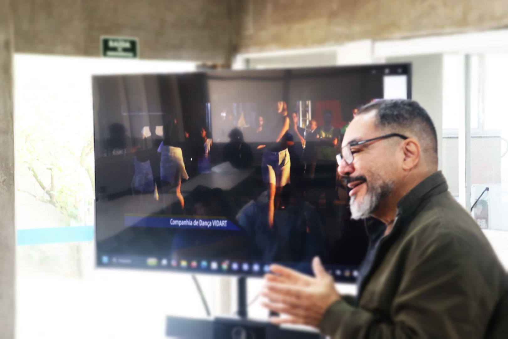 João Carlos Corrêa fala durante encontro na Fábrica de Cultura de Sapopemba, diante de uma tela de vídeo