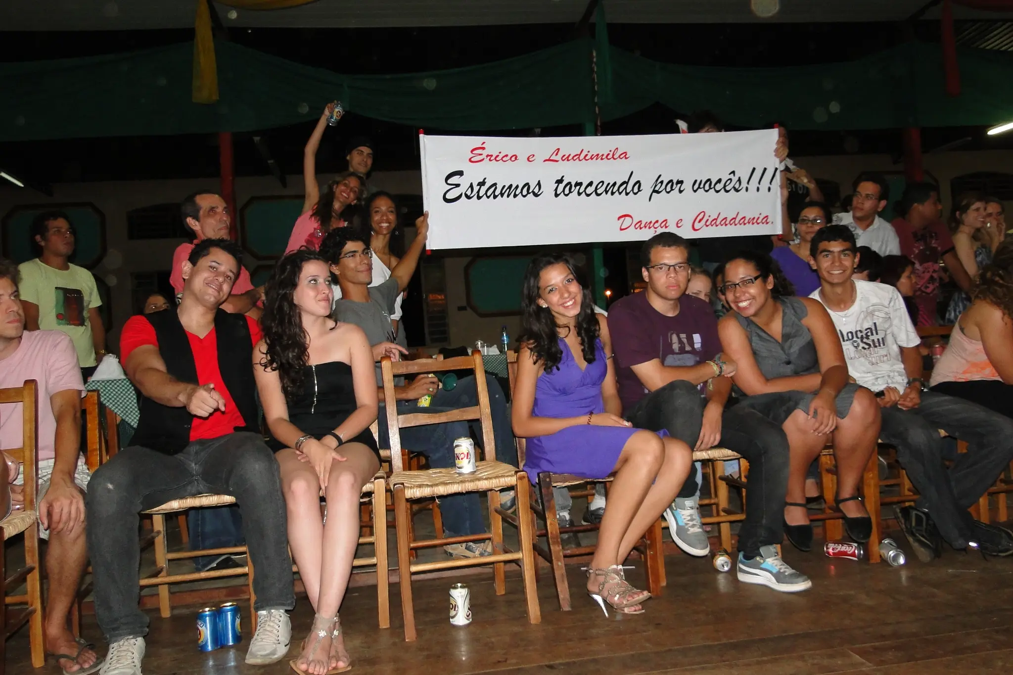 Integrantes e apoiadores do Projeto Dança e Cidadania reunidos com uma faixa de incentivo a dois participantes