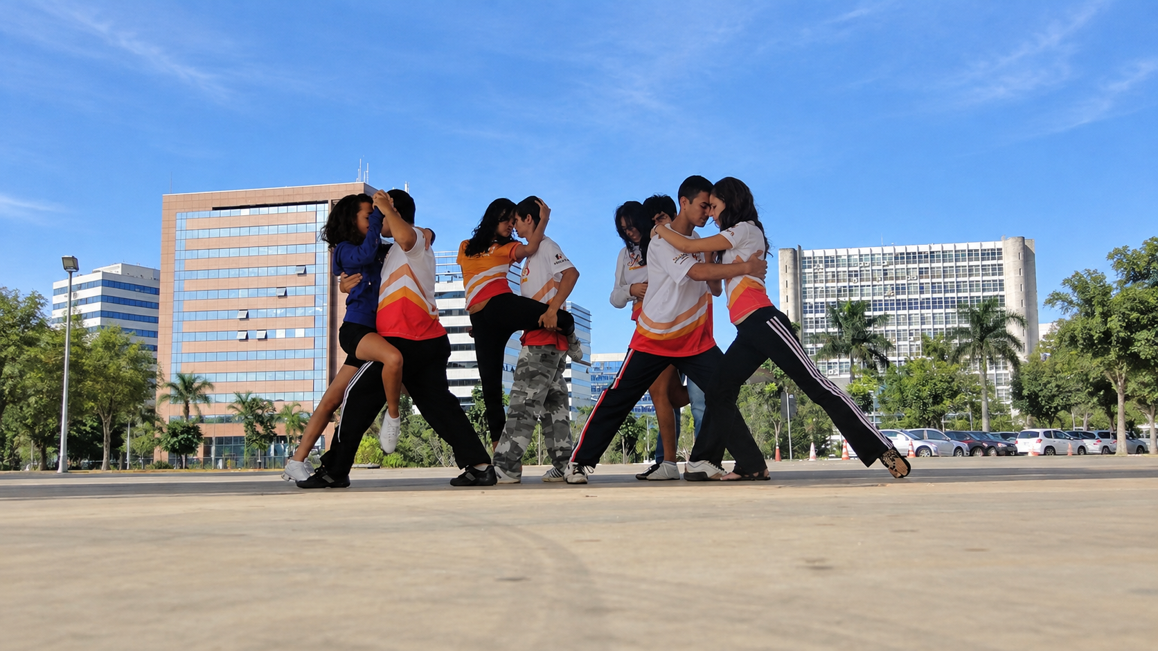 Jovens do Projeto Dança e Cidadania apresentam coreografia em pares ao ar livre, diante de edifícios de Brasília