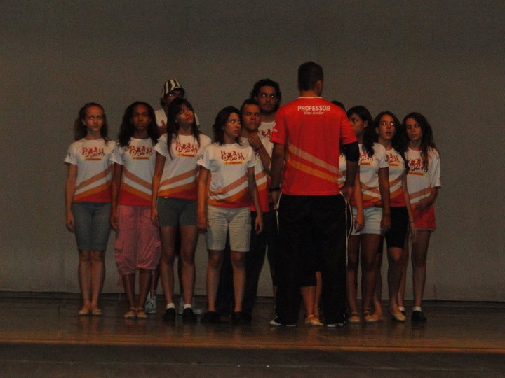 Dupla de jovens dança em apresentação noturna diante do público