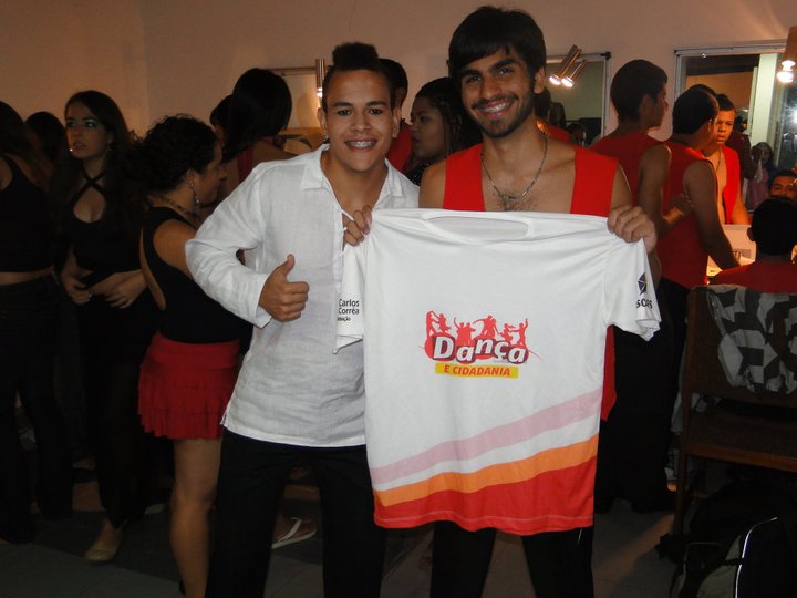 Grupo de jovens com camisetas vermelhas apresenta coreografia no palco de Dança e Cidadania