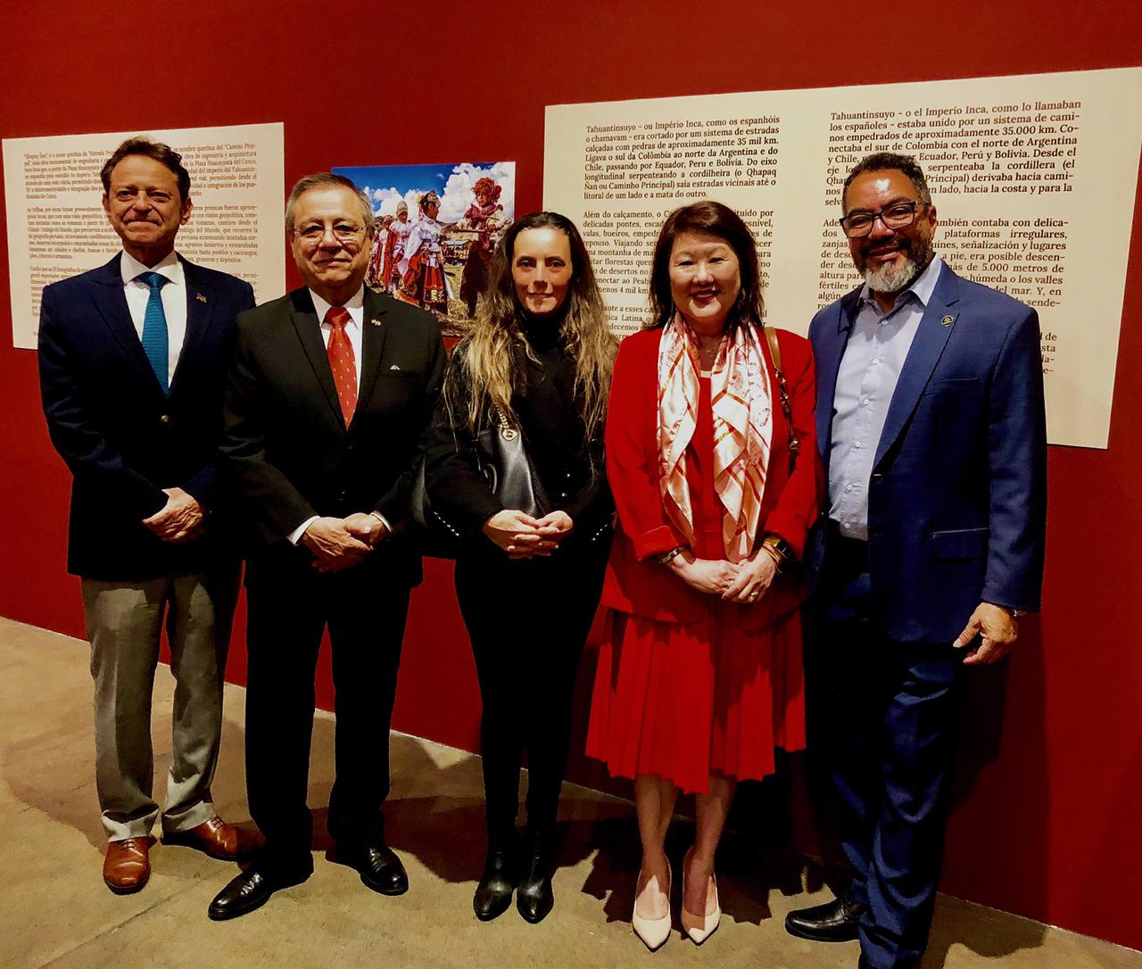 João Carlos Corrêa y cuatro invitados posan frente a paneles rojos de una exposición con textos sobre el Tahuantinsuyo y el Imperio Inca
