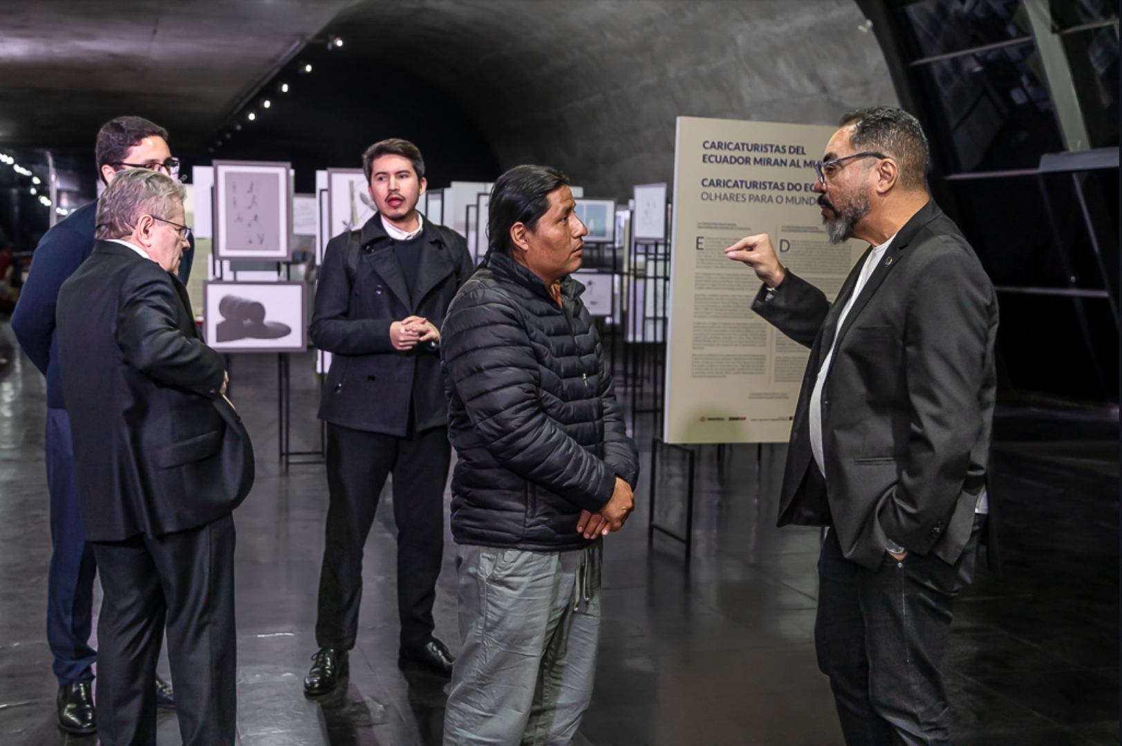 João Carlos Corrêa, Eduardo Durán Cousin e invitados conversan ante el panel de la exposición de caricaturistas ecuatorianos