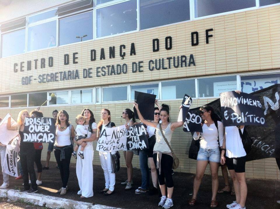 Participantes de mobilização em defesa da dança reunidos com faixas diante do Centro de Dança do Distrito Federal