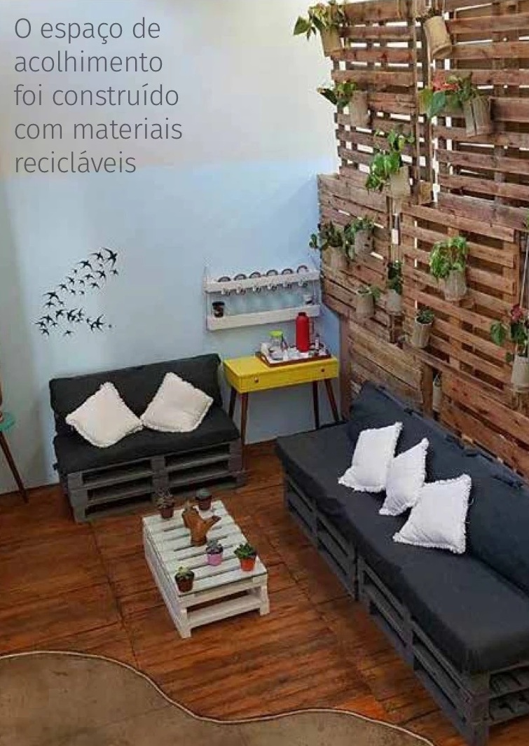 Espaço de acolhimento da Funarte Brasília com sofá, almofadas, plantas e mobiliário feito com pallets