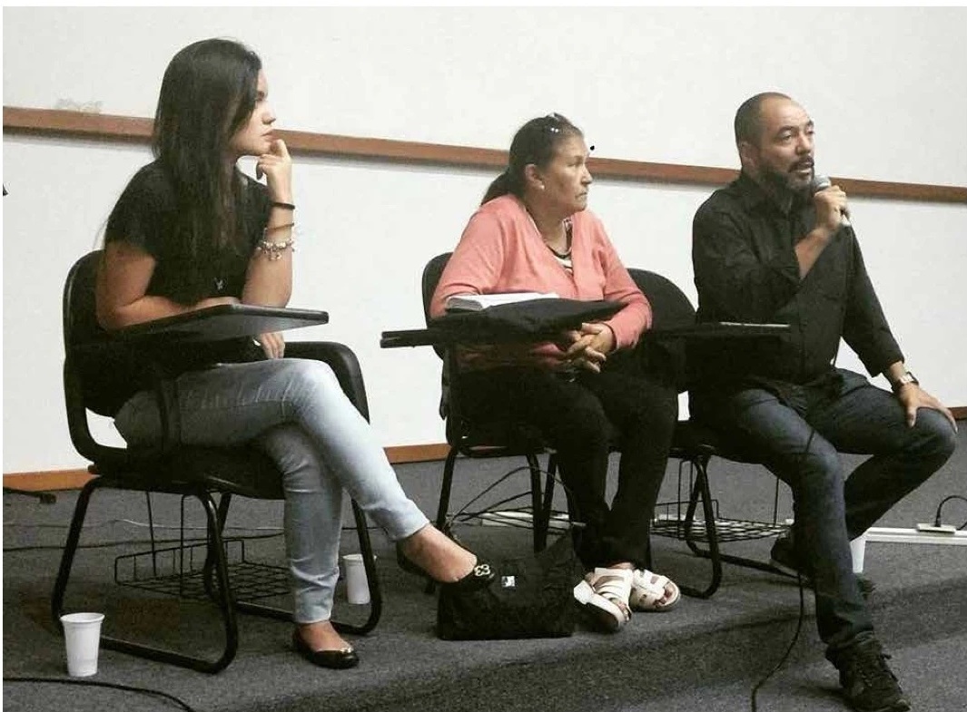 João Carlos Corrêa fala ao microfone ao lado de duas participantes durante atividade de representação da Funarte Centro-Oeste
