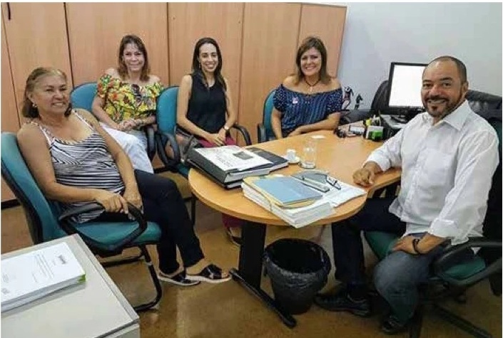 João Carlos Corrêa reunido em sala de trabalho com quatro mulheres durante agenda institucional