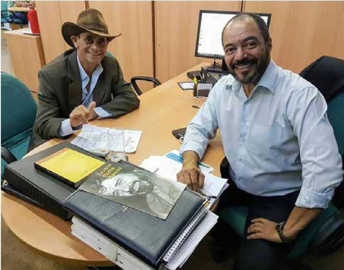 João Carlos Corrêa sentado em seu ambiente de trabalho durante reunião com um interlocutor