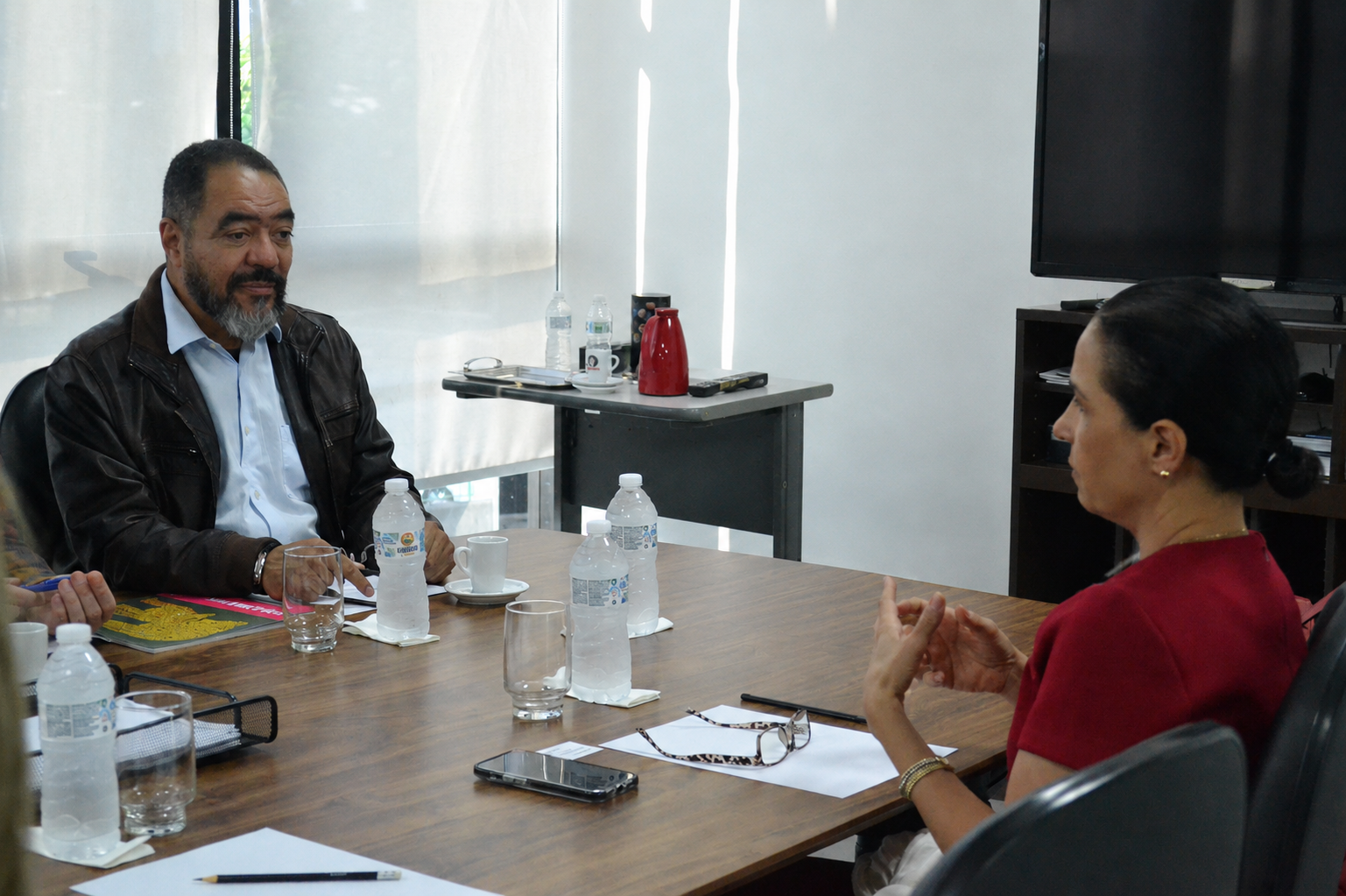 João Carlos Corrêa conversa con Rachel Coupaud durante una reunión en una sala del Memorial, con materiales de trabajo sobre la mesa