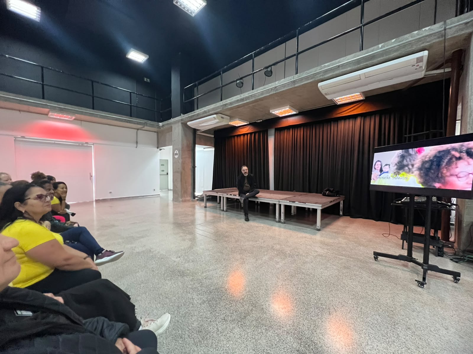 Participantes acompanham uma apresentação em vídeo na Fábrica de Cultura Itaim Paulista