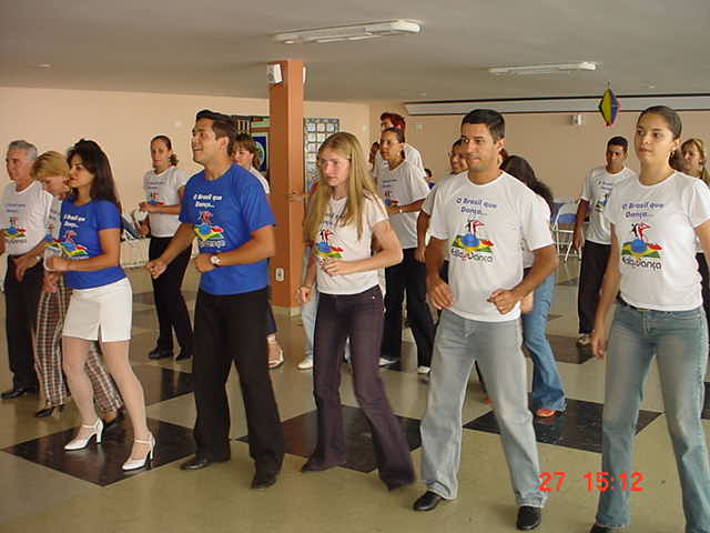 Grupo de participantes acompanha atividade de dança em formação coletiva