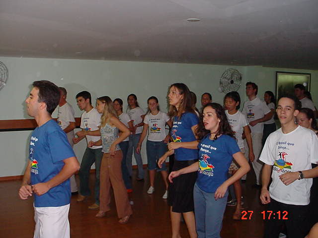 Participantes acompanham atividade coletiva de dança no salão