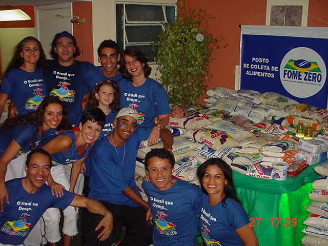 Equipe da I Maratona de Dança reunida junto ao posto de coleta e aos alimentos arrecadados