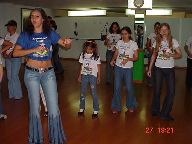 Grupo de adultos e crianças participa de atividade coletiva de dança
