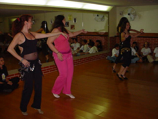 Duas participantes executam sequência coreográfica no salão