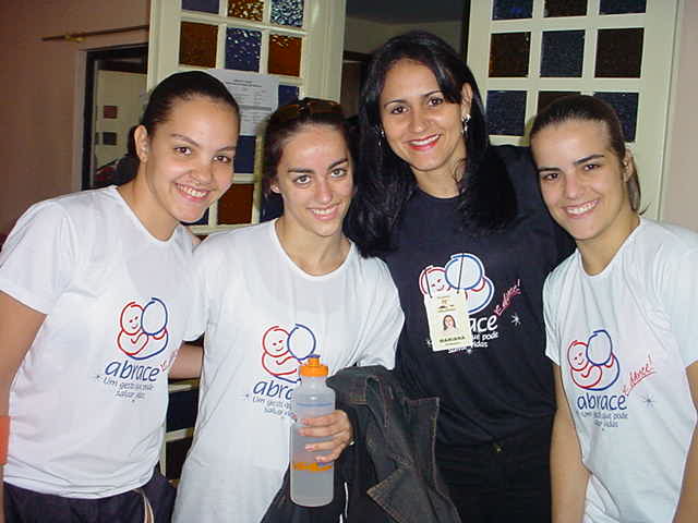 Quatro integrantes com camisetas da campanha ABRACE reunidas em retrato