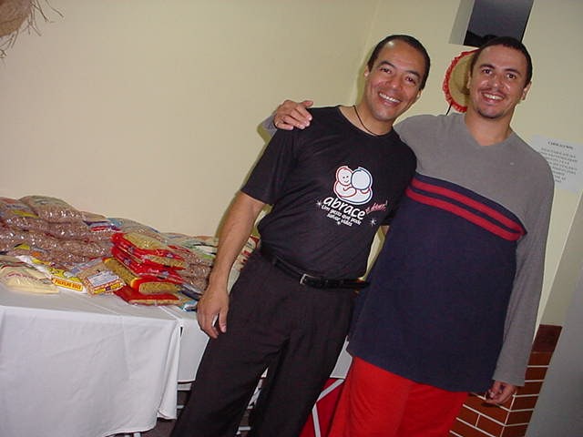 Dois participantes posam junto aos materiais arrecadados durante o evento