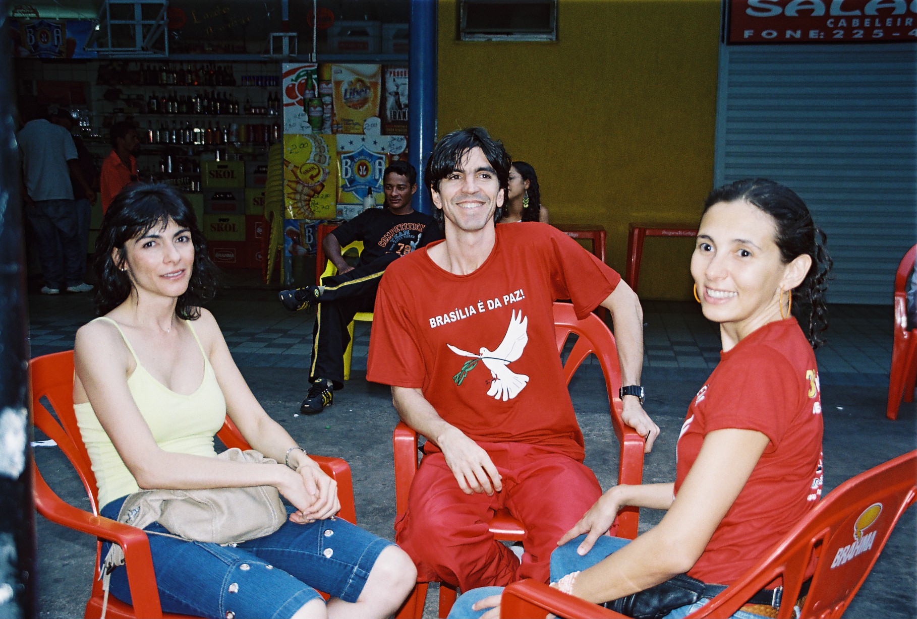 Três participantes com camisetas Brasília é da Paz conversam em área de convivência