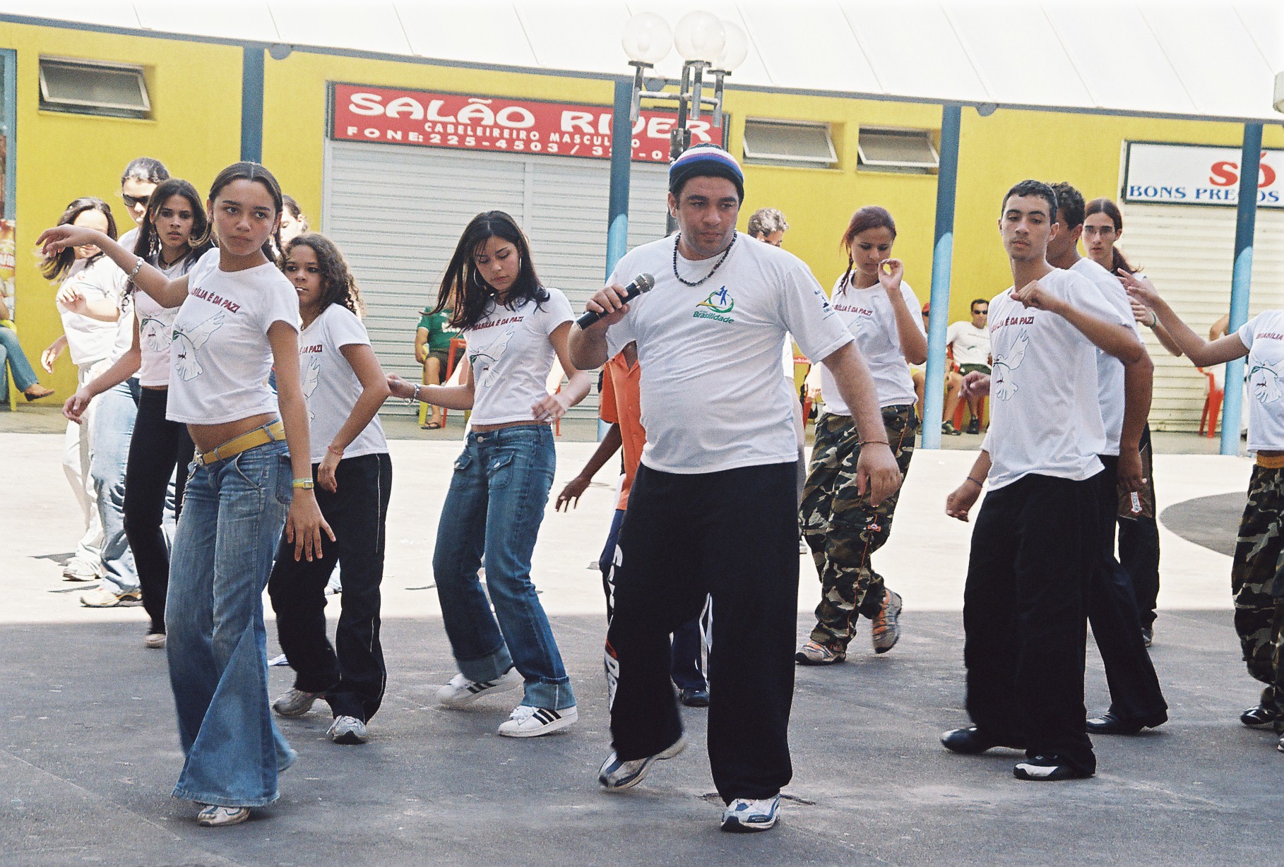 Grupo pratica sequência de dança conduzida por participante ao centro
