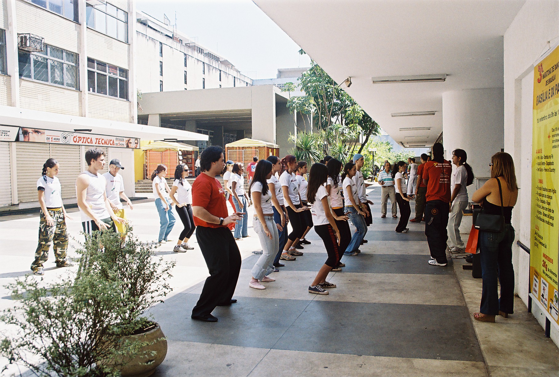 Grupo numeroso acompanha atividade coletiva de dança em uma das áreas do evento