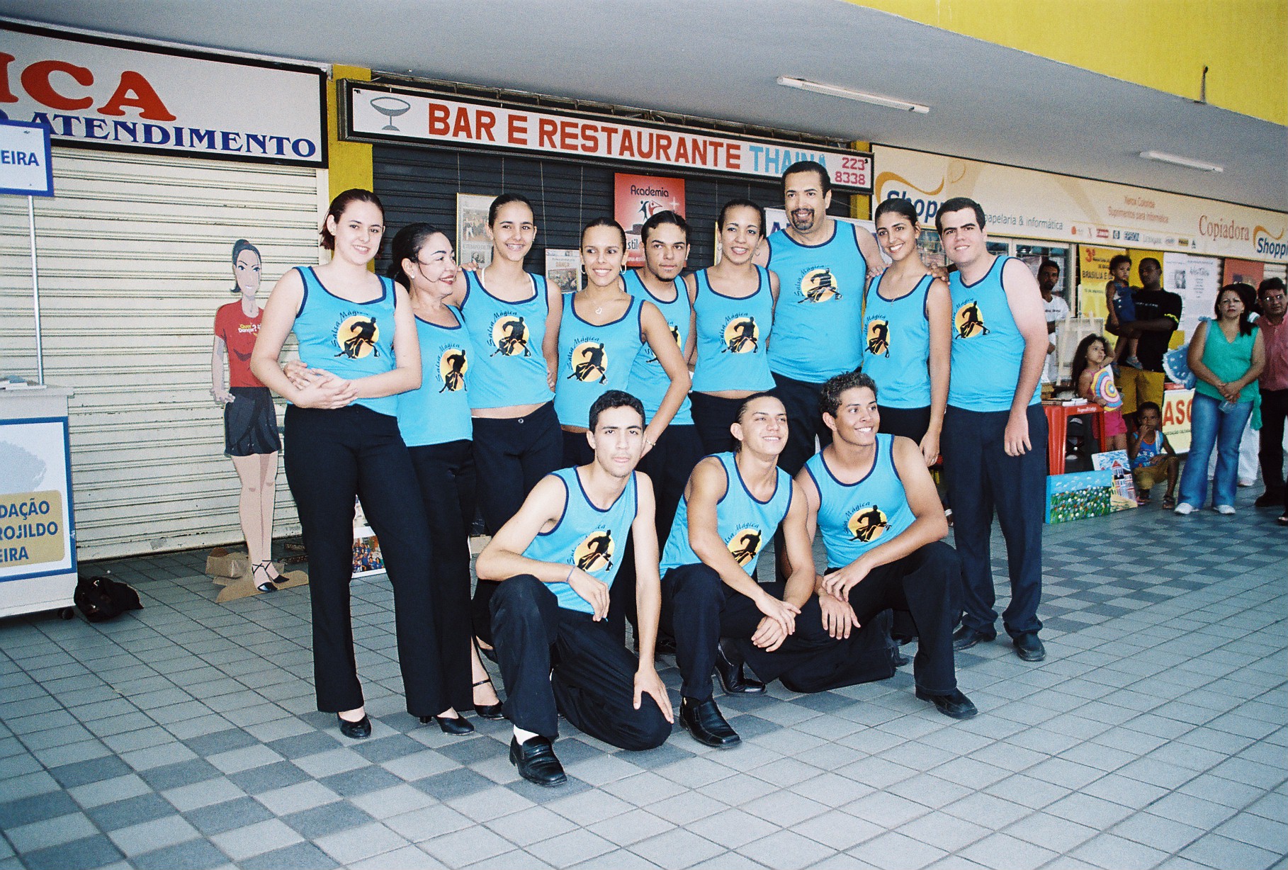 Equipe com camisetas azuis reunida em retrato coletivo