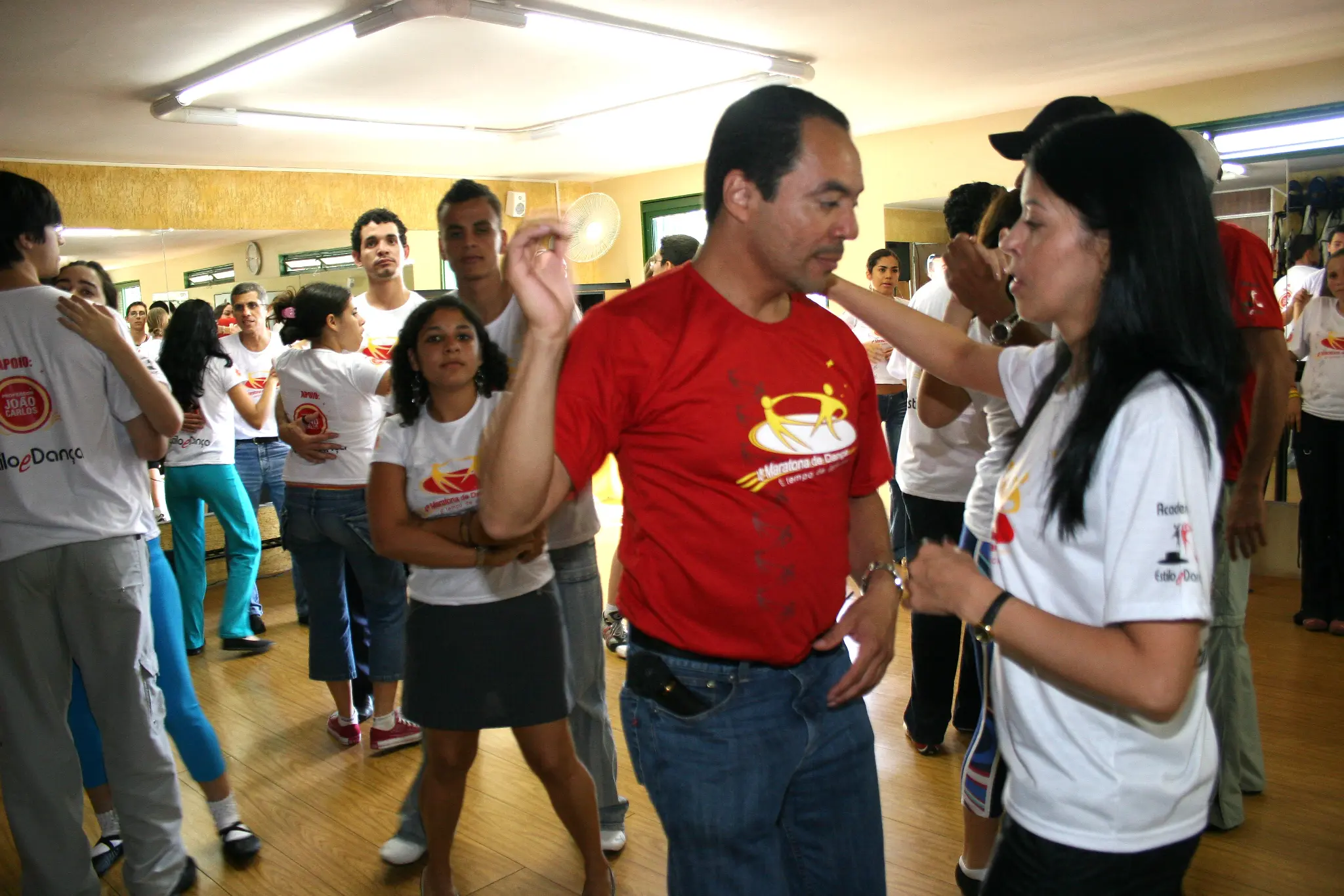 Integrante com camiseta vermelha conversa com participante durante o evento