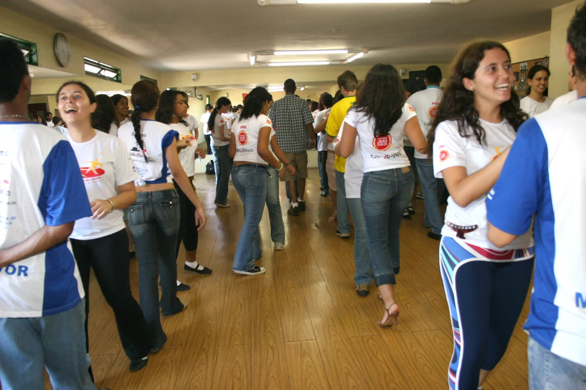 Salão ocupado por participantes em atividades de dança e convivência