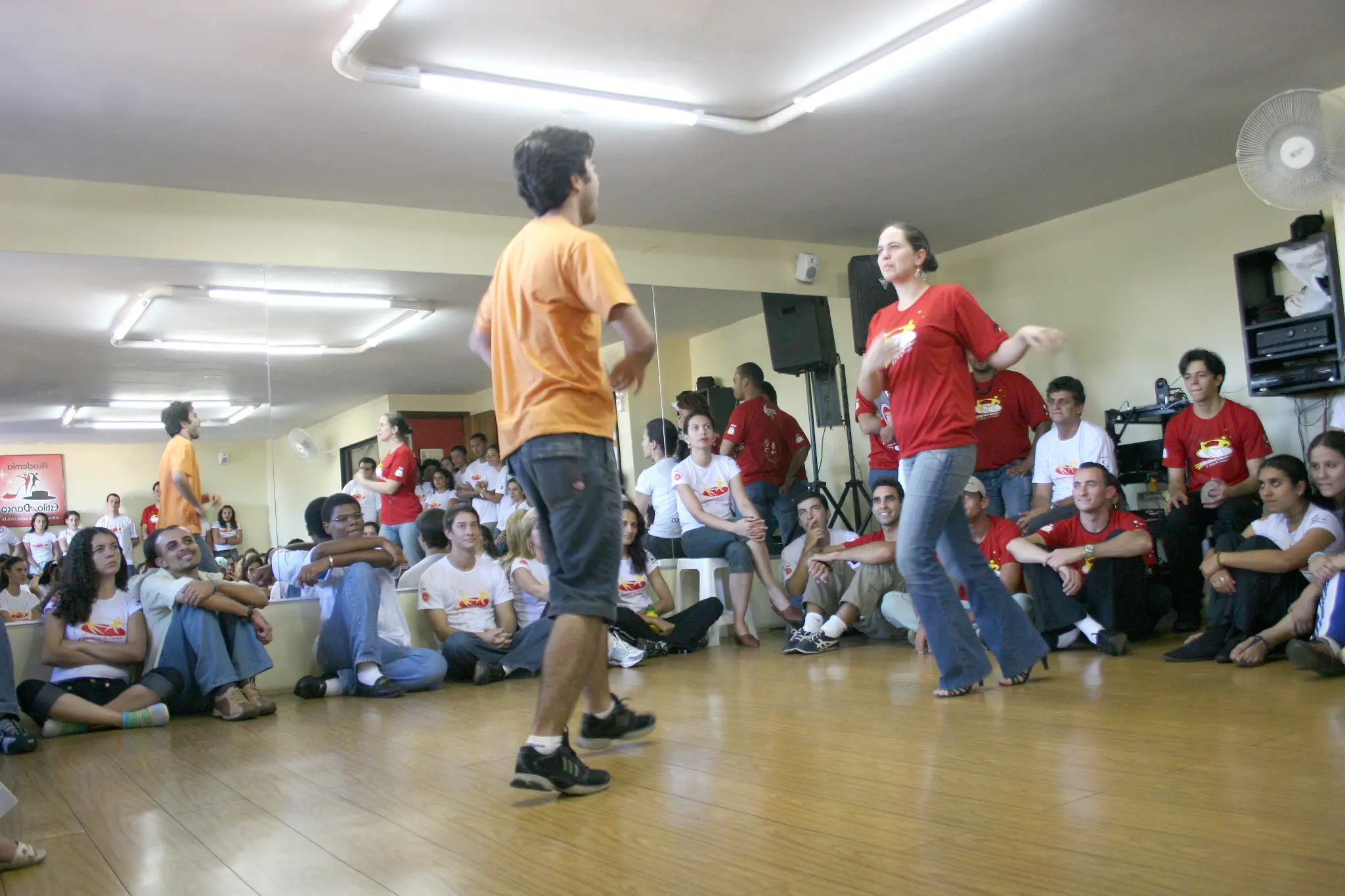 Dois participantes realizam apresentação de dança no centro do salão
