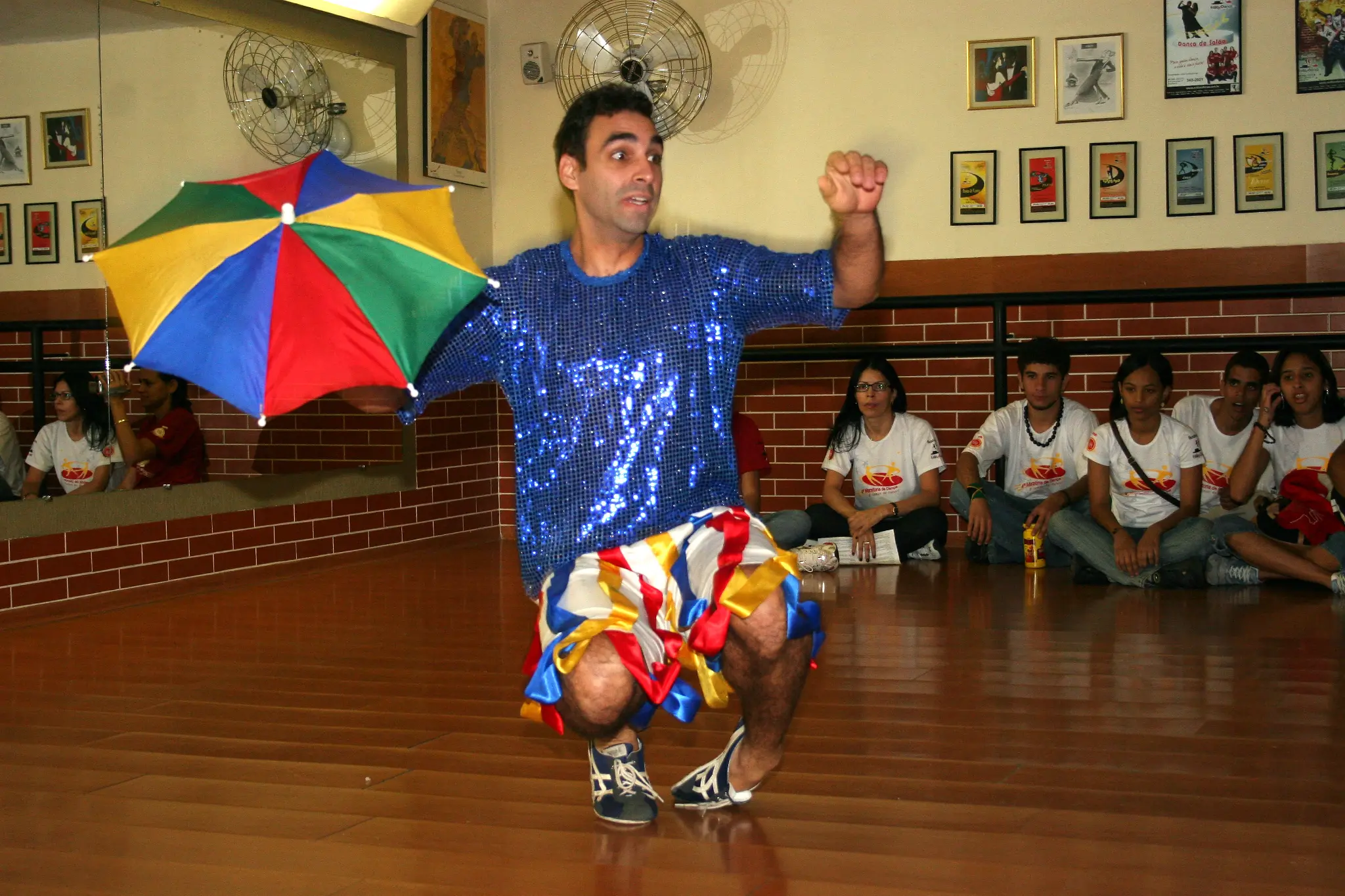 Artista apresenta número com guarda-chuva colorido no salão