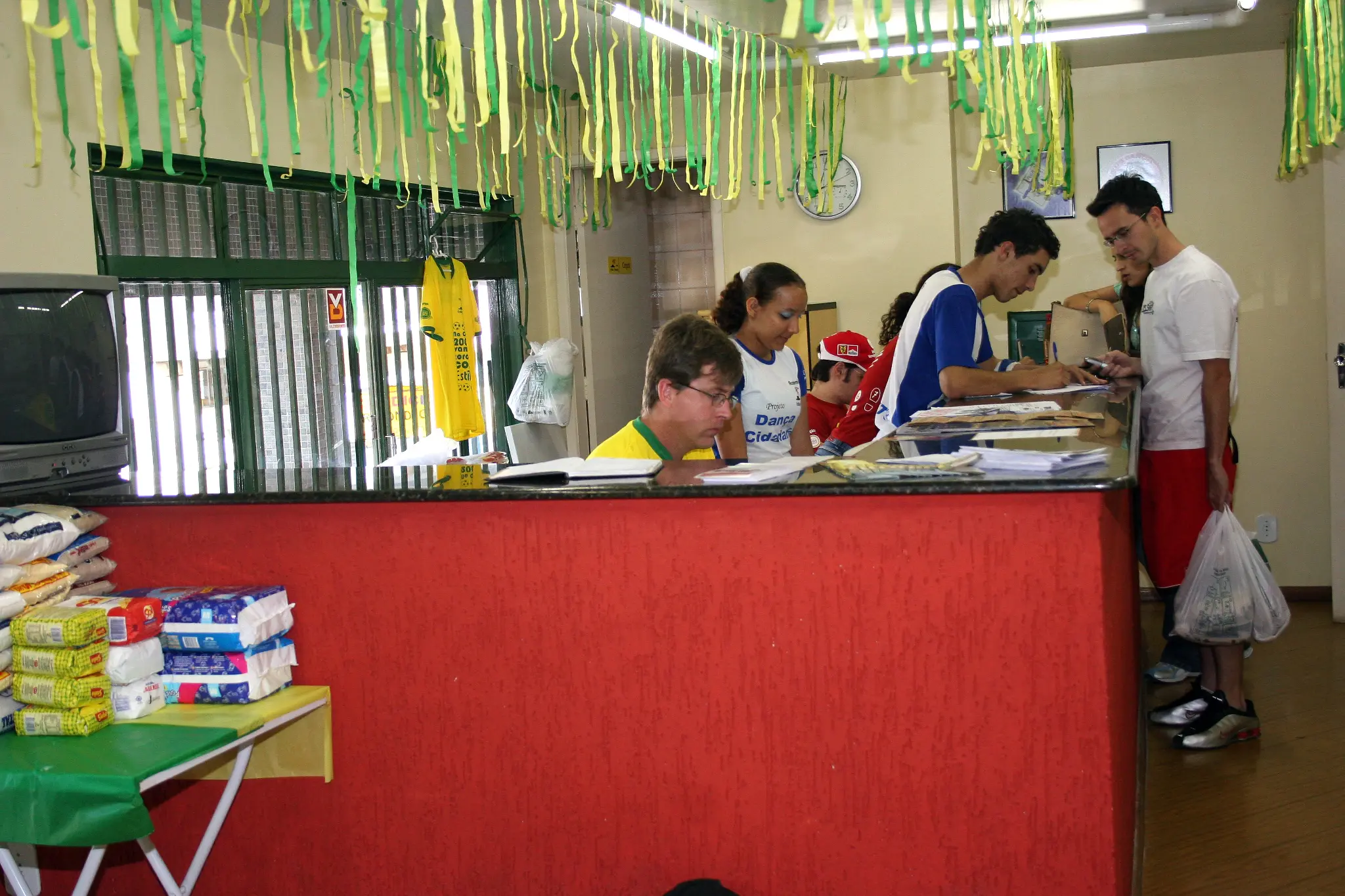 Equipe trabalha junto ao balcão de atendimento e aos materiais do evento