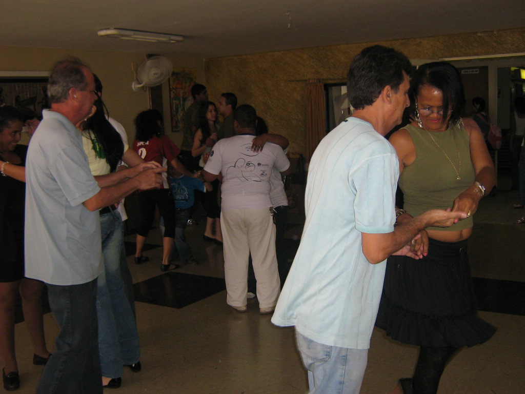 Participantes dançam em pares durante atividade coletiva