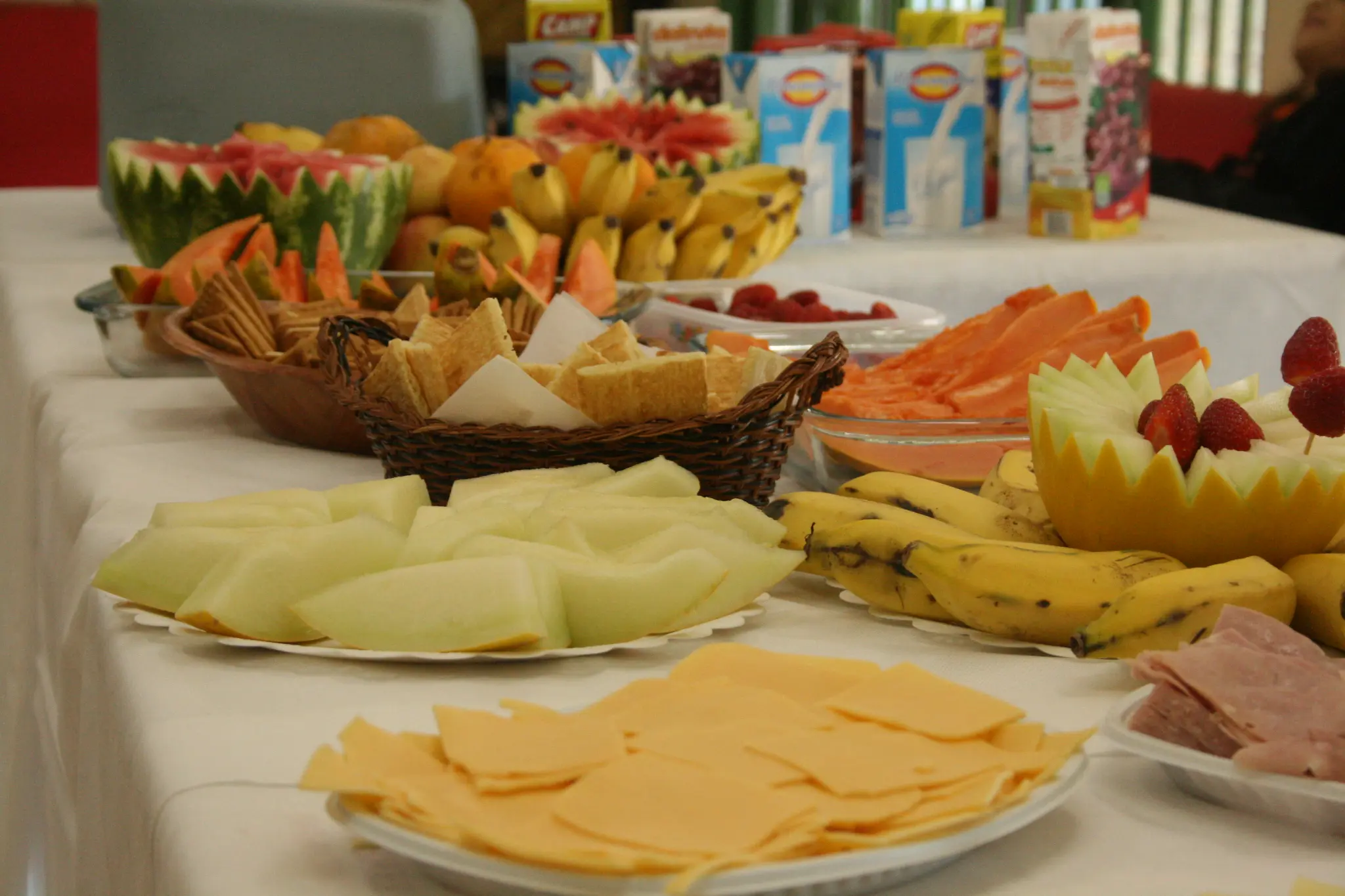 Mesa com frutas, frios e alimentos preparada para a convivência do evento